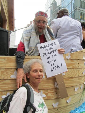 This photo by Jon Fein, echoing one of the prayers of Yom Kippur, shows Reb Arthur with Terry Kardos and her sign aboard Noah’s Ark at the People’s Climate March, 9/21/14]